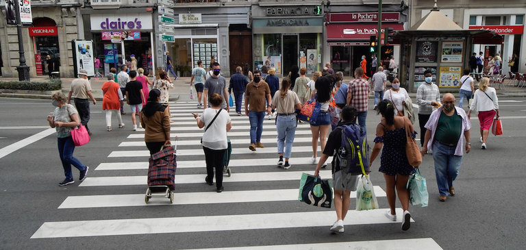 Varias personas con mascarilla cruzan una calle en el centro de Santander. / Hardy