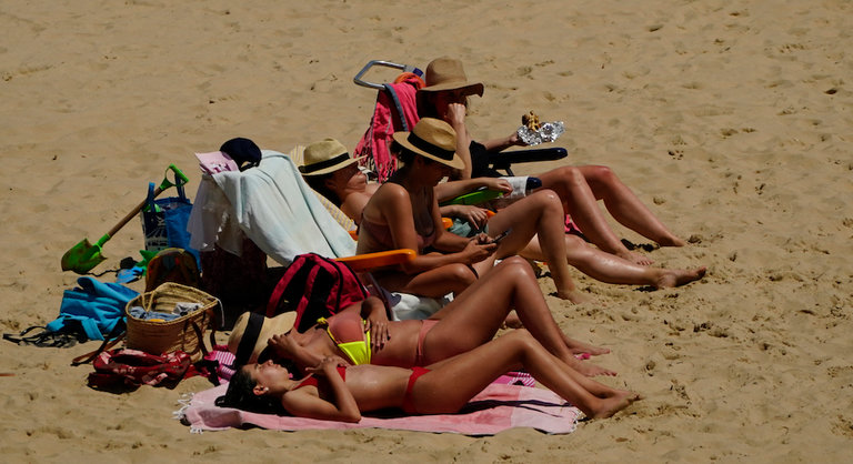 Varias personas sin mascarilla en la playa del Sardinero. / Hardy