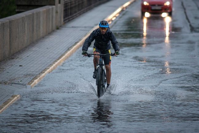 Un ciclista cruza el Puente Nuevo de Ourense bajo una intensa lluvia, este miércoles. La Dirección Xeral de Emerxencias e Interior de la Vicepresidencia de la Xunta de Galicia ha activado una alerta naranja por tormentas y fuertes precipitaciones en las provincias de Lugo y Ourense. EFE/ Brais Lorenzo