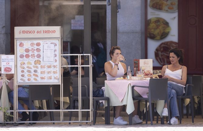 Dos mujeres comen en una terraza del centro de la capital