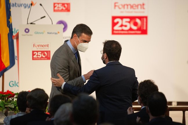 El presidente del Gobierno, Pedro Sánchez (i) y el president de la Generalitat, Pere Aragonés (d), se saludan en un acto el 7 de junio de 2021 en Barcelona