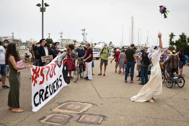 Una performance en el Puerto de València simula una bora para protestar contra el reinicio de la actividad de cruceros