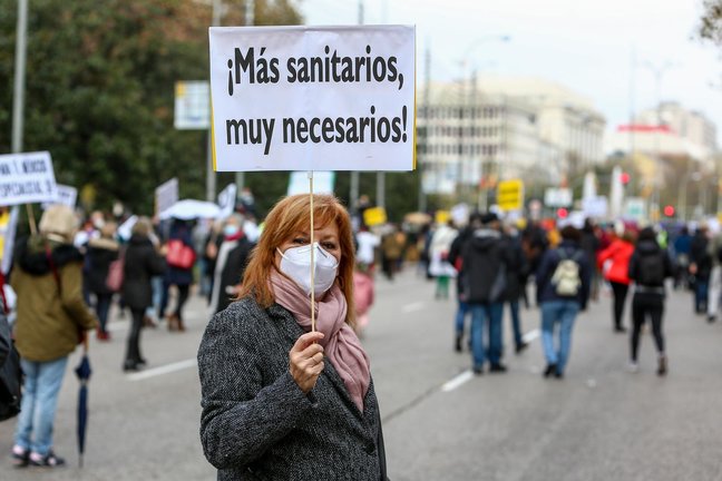 Archivo - Una mujer sostiene una pancarta donde se lee "¡Más sanitarios, muy necesarios!" durante una manifestación de la Marea Blanca en Madrid.