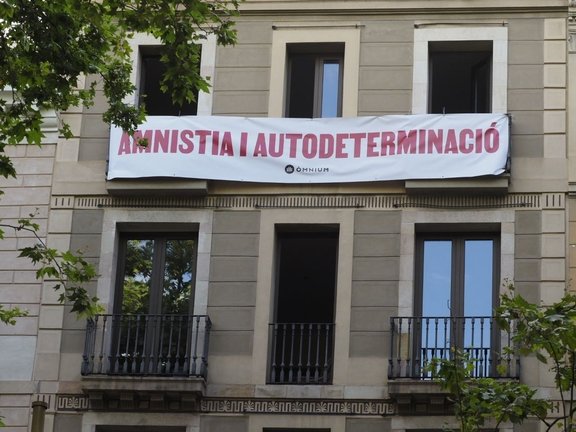 Òmnium despliega una pancarta ante el Liceu para pedir a Sánchez amnistía y autodeterminación