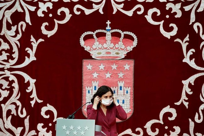 La presidenta madrileña, Isabel Díaz Ayuso, se coloca la mascarilla mientras preside la ceremonia de toma de posesión de los nuevos consejeros de la Comunidad de Madrid, este lunes, en la Real Casa de Correos. EFE/Juan Carlos Hidalgo
