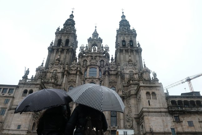 Archivo - Una pareja observa la catedral de Santiago sin andamios después de varios años de obras.