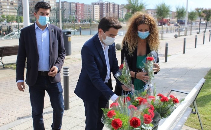Los miembros del PSEO poniendo flores en el Barrio Pesquero de Santander. / ALERTA