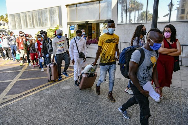 Varios inmigrantes subsaharianos hacen cola con maletas para viajar a la península, donde serán acogidos por diferentes ONGs, en el CETI de Ceuta, a 23 de junio de 2021, en Ceuta (España). Los 23 inmigrantes que viajan hoy a la península, proceden en su m