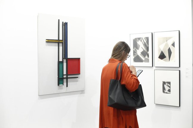 Archivo - Una mujer mira su móvil durante la 38ª edición de la Feria Internacional de Arte Contemporáneo ARCOmadrid.     