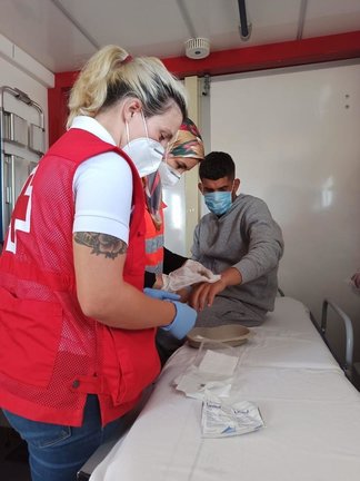 Personal de Cruz Roja atiende a una persona migrante llegada a Calp este lunes en patera