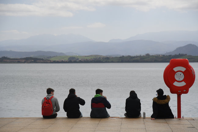 Varios jóvenes sentados frente a la bahía de Santander. / Hardy