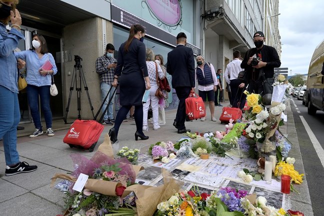 Varias personas pasan al lado del altar colocado en la acera donde fue golpeado Samuel, el joven asesinado en A Coruña el pasado sábado 3 de julio.