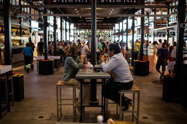 Dos personas sentadas en una mesa durante la reapertura del Mercado de San Miguel en Madrid