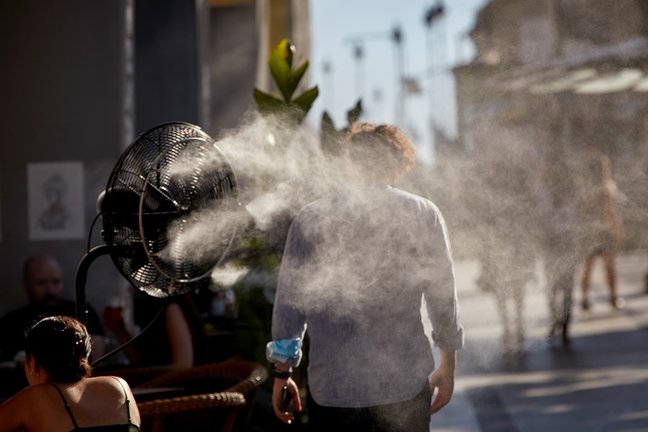 Un hombre camina al lado de un difusor de vapor de agua de un restaurante de la calle Alcalá, a 2 de julio de 2021, en Madrid, (España). 