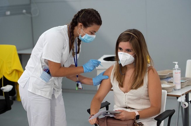 Una joven recibe la primera dosis de la vacuna Pfizer en el Hospital Zendal, en Madrid (España).