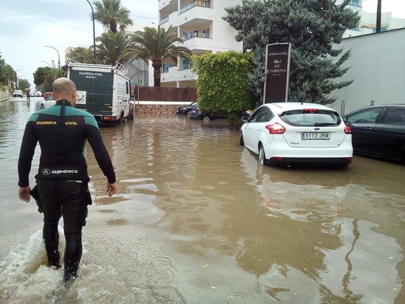 Archivo - Un agente camina en una carretera afectada por una inundación en el sur de Mallorca.