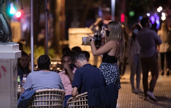 Archivo - Una camarera atiende a varias personas en la terraza de un bar de copas en la primera noche sin toque de queda tras el fin del estado de alarma, a 09 de mayo de 2021, en Sevilla (Andalucía, España). Andalucía pone fin desde este domingo, al deca