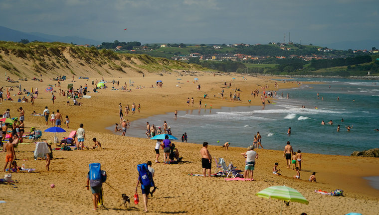 Varias personas en la playa de Liencres, Cantabria. / Hardy