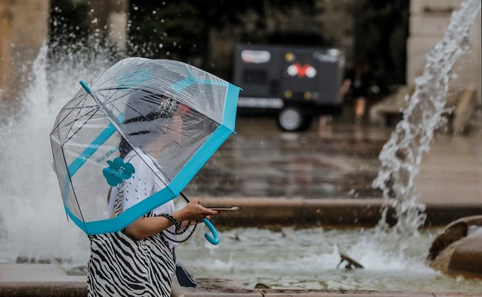 Una persona sostiene un paraguas mientras llueve, a 26 de julio de 2021, en Valencia, Comunidad Valenciana, (España). Para esta jornada, con nivel máximo naranja, se espera cielo nuboso que tenderá a intervalos nubosos al final y viento de componente este