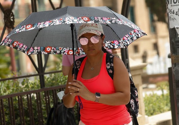 Una mujer se protege del sol con un paraguas durante un día de alerta roja por altas temperaturas, a 12 de julio de 2021, en la ciudad de Murcia, Murcia (España). 