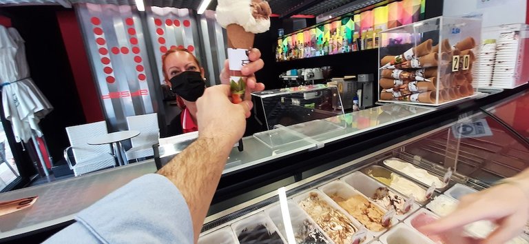 Una dependienta de la heladería Escudero en Torrelavega atiende a un cliente. / S. Díaz