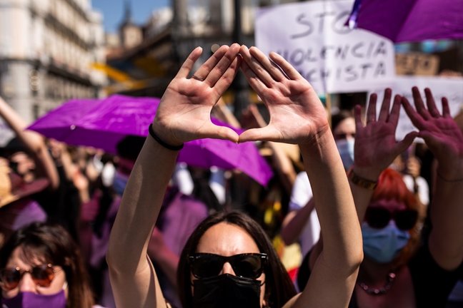Archivo - Una mujer hace un gesto feminista, durante una manifestación en Madrid.