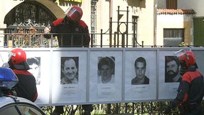 Agentes de la Ertzaintza retiran las fotos de presos etarras en Mondragón.EFE / ARCHIVO