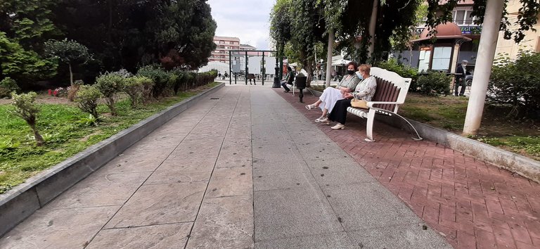 Dos personas con mascarilla sentadas en la Plaza José María González Trevilla. /  S. DÍAZ