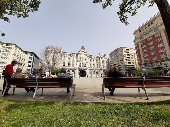 Varias personas sentadas en la plaza del Ayuntamiento de Santander. / S. Díaz