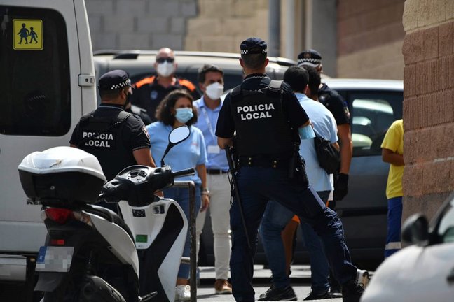 Varios agentes y vehículos de la Policía Local de Ceuta acompañan a menores no acompañados hacia una furgoneta para ser traslados a Marruecos