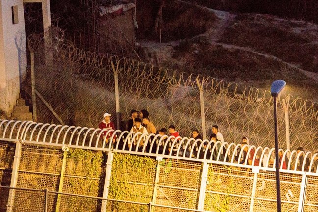 Archivo - Varios marroquíes intentan llegar a suelo español desde la frontera que separa Melilla y Marruecos