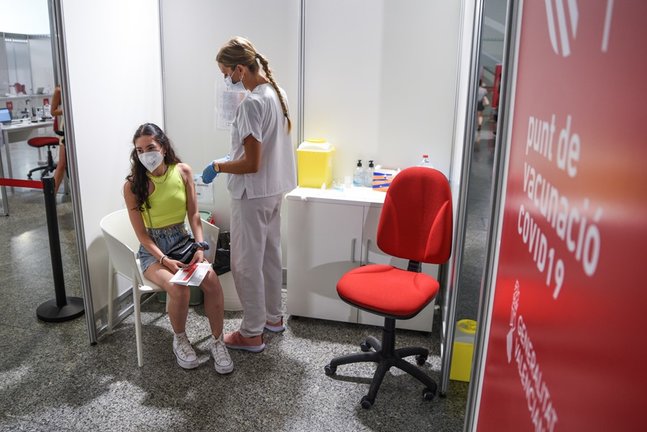 Una sanitaria vacuna a una adolescente con la primera dosis de la vacuna Moderna en la Ciudad de las Artes, a 16 de agosto de 2021, en Valencia, Comunidad Valenciana, (España).
