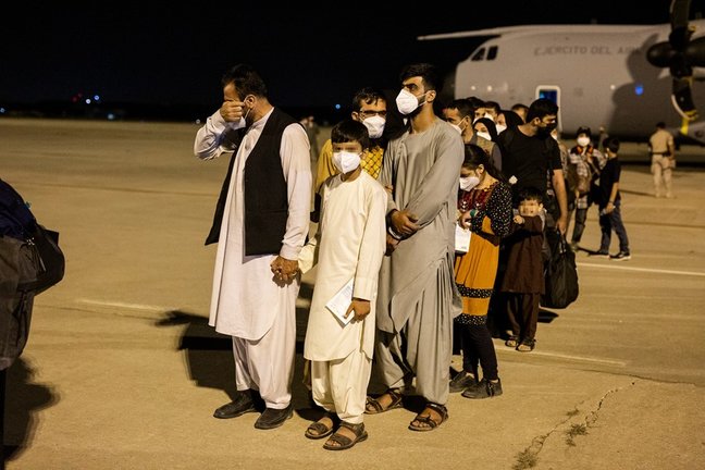 Un hombre emocionado acompañado de varias personas a su llegada a la pista tras bajarse del avión A400M en el que ha sido evacuados de Kabul