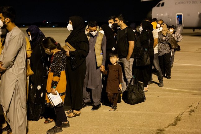 Varias personas repatriadas de Afganistán llegan a la pista tras bajarse del avión A400M en el que ha sido evacuados de Kabul