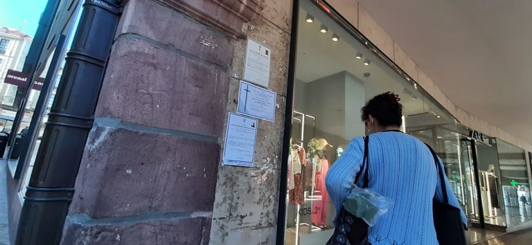 Una persona ojea las esquelas puestas en la pared al lado de la tienda Zara de Torrelavega. / S. Díaz