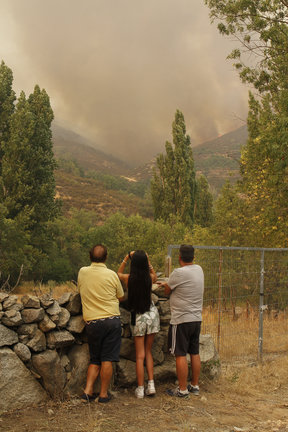 Tres vecinos contemplan el incendio en el término abulense de Navalacruz, a 16 de agosto de 2021, en Ávila, Castilla y León (España)