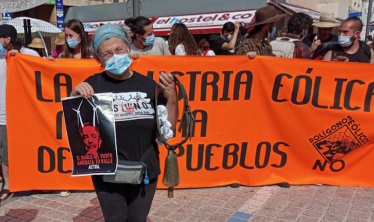 Una persona sostiene un cartel que dice: "El Diablo del viento amenaza tu valle' y sale la imagen de Revilla. / @DPasiegos