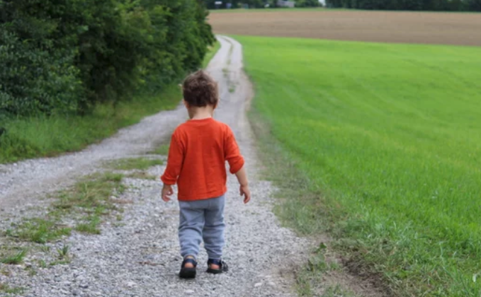niño caminando por un campo
