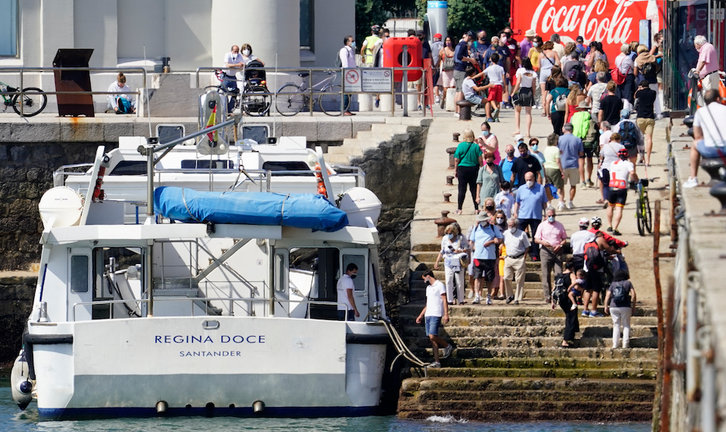 Varias personas se disponen a subir a uno de los barcos en Santander. / Hardy