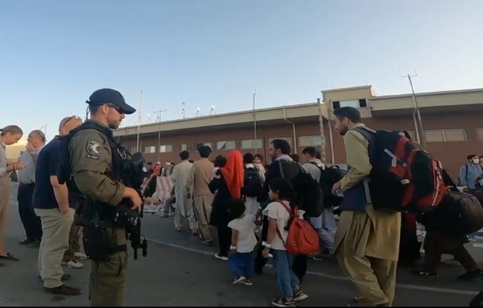 Imagen distribuida por la Policía Nacional de los agentes del GEO y UIP que custodian a afganos antes de viajar en aviones a España