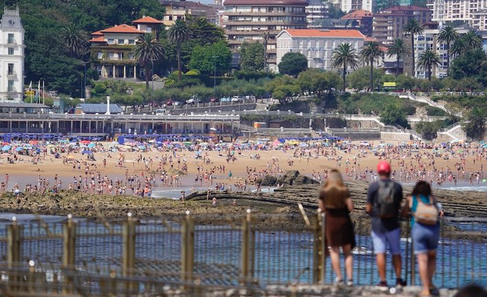 Tres personas miran hacia la playa del Sardinero en la península de la Magdalena de Santander. / Hardy