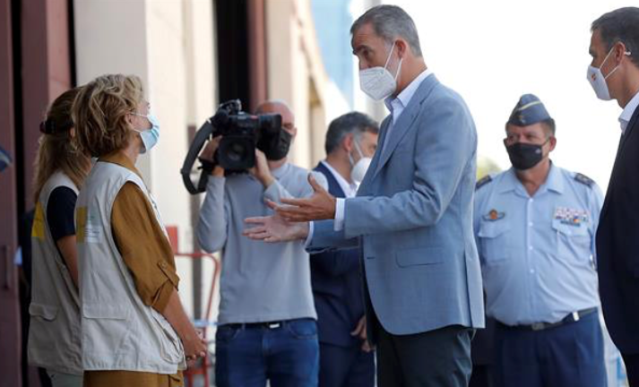 El rey Felipe VI y el presidente del Gobierno, Pedro Sánchez, conversan con varias personas durante su visita este sábado al centro de acogida temporal instalado en la base de Torrejón de Ardoz para agradecer a los implicados con motivo de la operación de repatriación desde Afganistán. EFE/Chema Moya