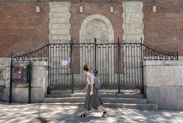 Archivo - Una mujer pasa al lado de una de las puertas de los Jardines de Sabatini