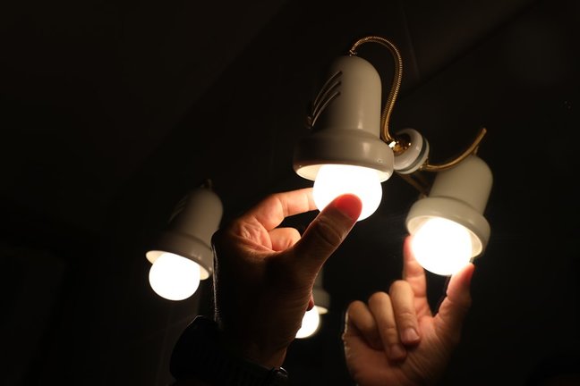 Una persona cambiando la bombilla de una lámpara