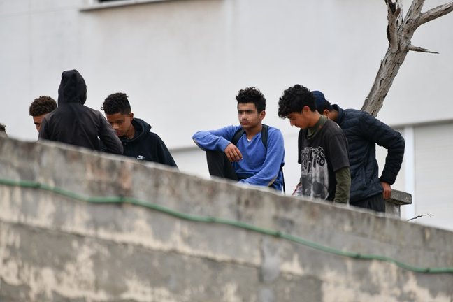 Varios menores migrantes, en el tejado de una nave industrial, a 27 de agosto de 2021, en Ceuta, (España). La Policía Nacional ha desalojado a varios menores que se encontraban en el tejado de esta vieja nave industrial, en la zona portuaria de Ceuta.