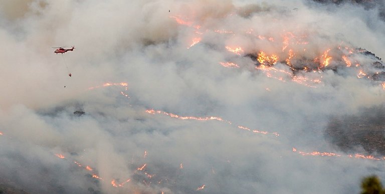 Helicóptero contra incendio intentando apagar el fuego de la Sierra Bermeja, visto desde el cerro de la Silla de los Huesos, a 13 de septiembre 2021 en Casares (Málaga) Andalucía