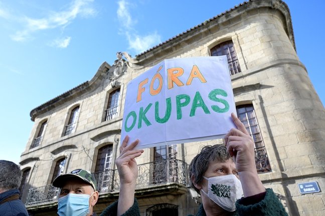 Archivo - Una persona sostiene un cartel donde se puede leer "Fuera okupas" durante la marcha cívica para pedir la "devolución" al patrimonio público de la Casa Cornide, en manos de la familia Franco, en A Coruña, Galicia, (España), a 7 de noviembre de 20