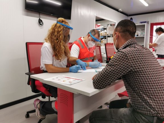 Voluntarios de Cruz Roja atienden a una de las 376 personas llegadas en patera a lo largo del fin de semana en Almería