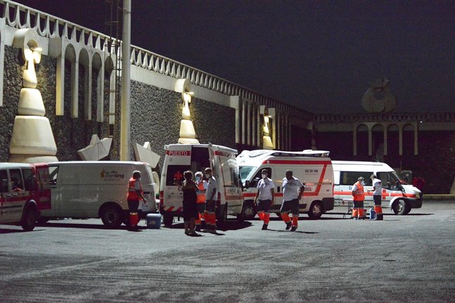 Vehículos de Cruz Roja, atienden a varios migrantes a su llegada al muelle de La Restinga tras ser rescatados de una patera el pasado 23 de agosto