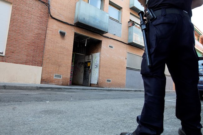 Archivo - Un agente de Policía Nacional frente a un edificio de la calle José Garrido que estaba okupado, a 20 de julio de 2021, en Madrid (España).